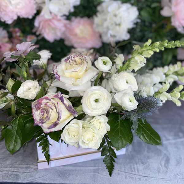 White and blush floral arrangement with roses and ranunculus in a box