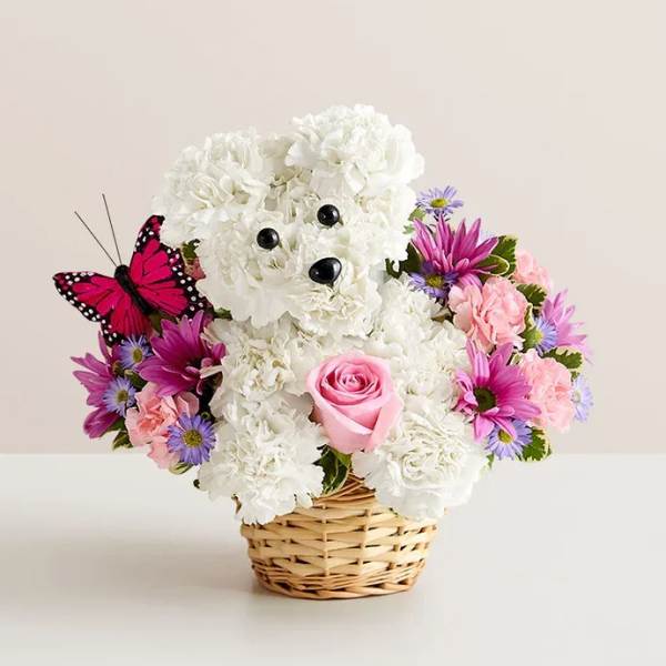 White teddy bear floral arrangement in a wicker basket with pink and purple flowers