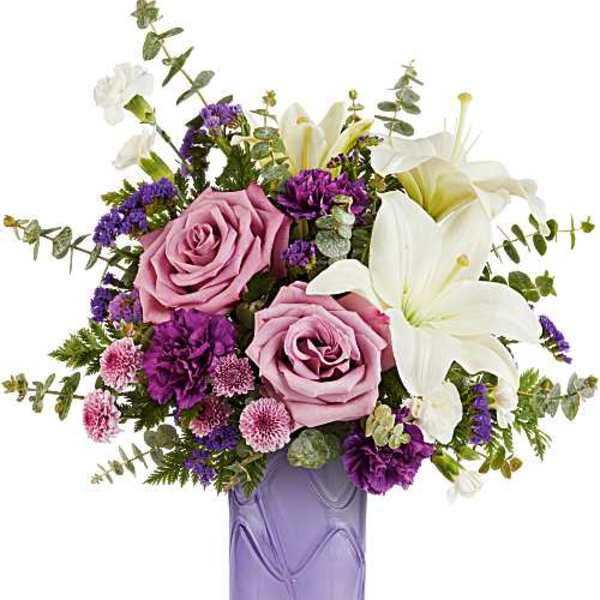 Pink roses and white lilies in a purple glass vase