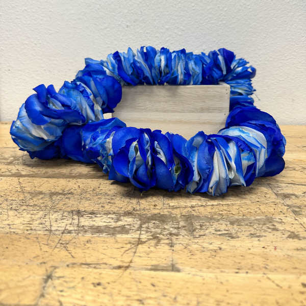 Blue floral wreath around a small wooden block