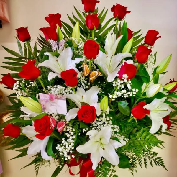 Red roses and white lilies in a tall glass vase