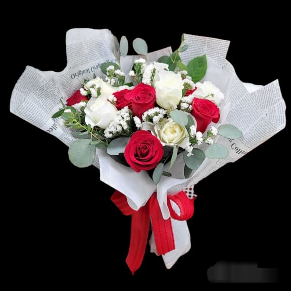 Bouquet of red and white roses wrapped in newspaper-style paper