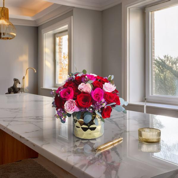 Bouquet of red and pink roses in a gold vase