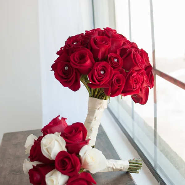 Two rose bouquets with red and white blooms, one tied with white ribbon