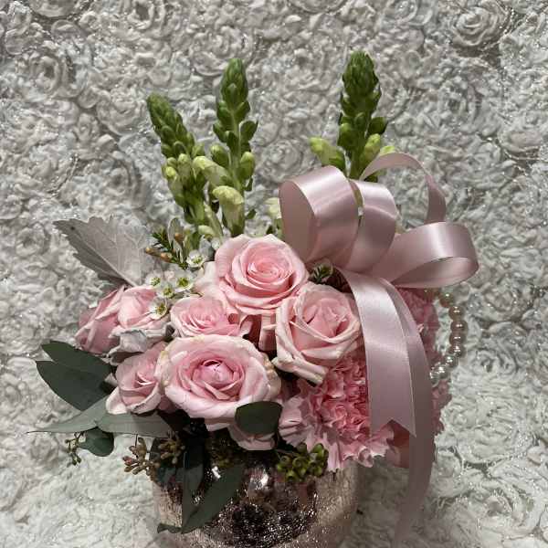 Pink rose arrangement in a glittery vase with a satin ribbon