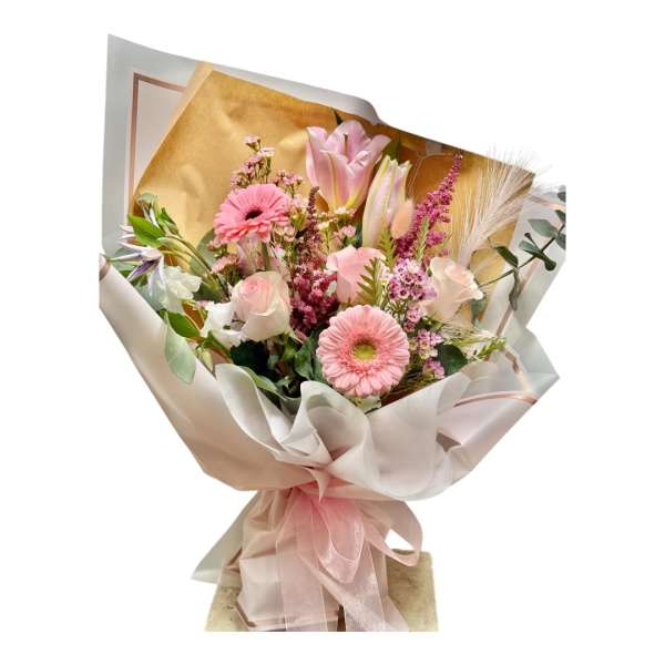 Pink mixed flower bouquet wrapped in beige paper with a pink ribbon