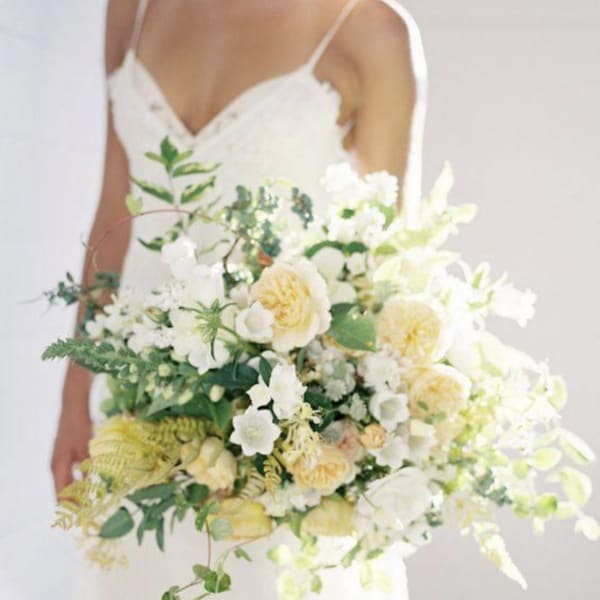 Bride holding a large white and pale yellow bouquet