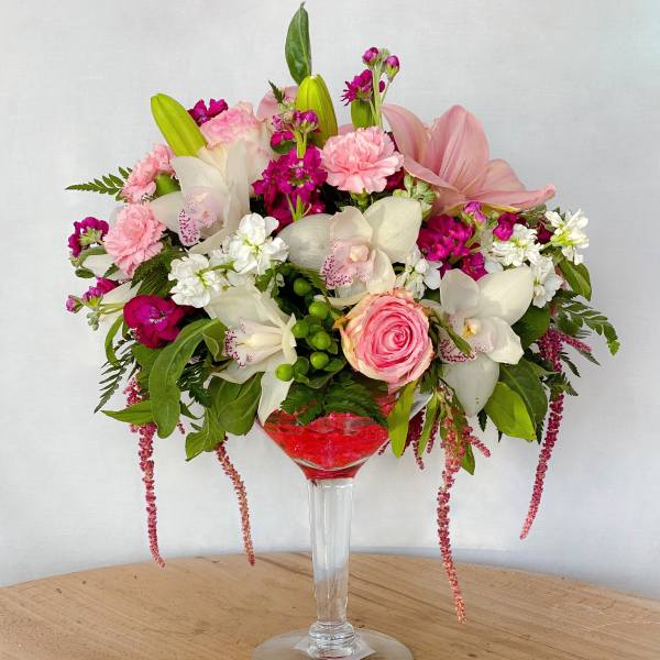Pink and white floral arrangement in a tall glass vase