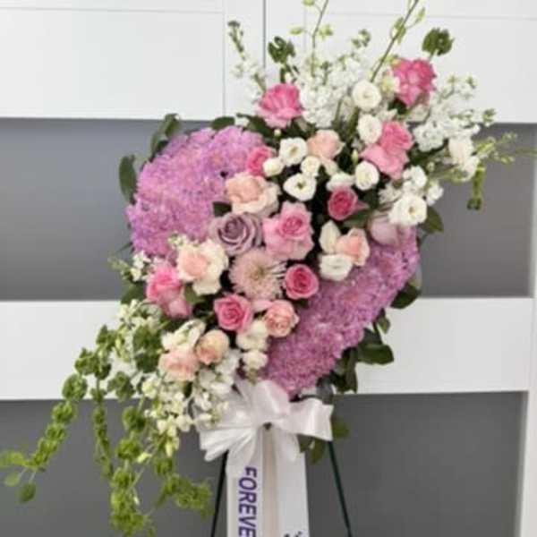 Standing floral spray with pink and white flowers on an easel