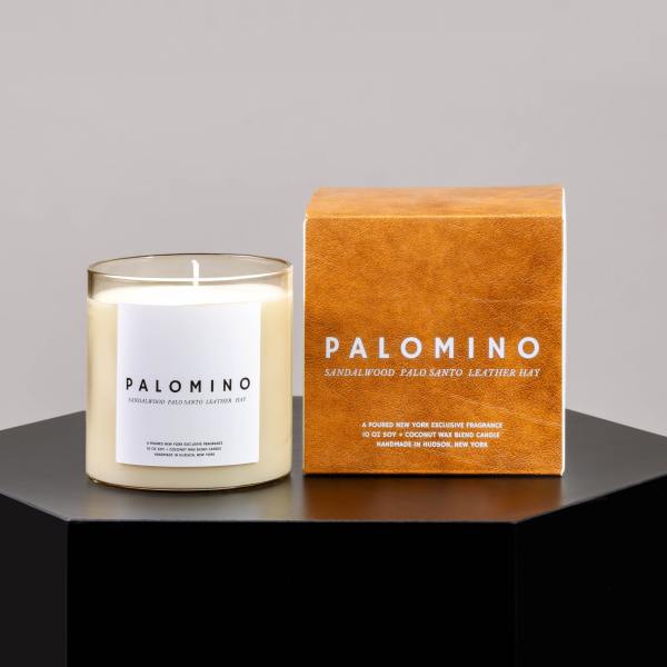 Scented candle in a glass jar beside its orange box