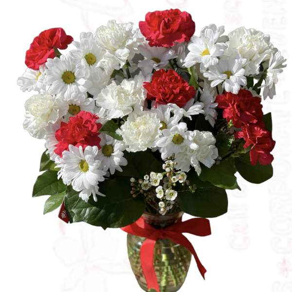 Bouquet of red carnations and white daisies in a glass vase