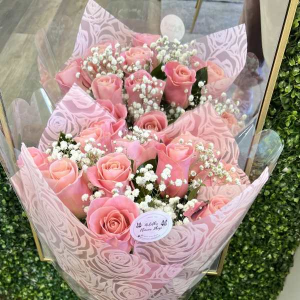 Pink rose bouquet with baby's breath in patterned wrap and ribbon