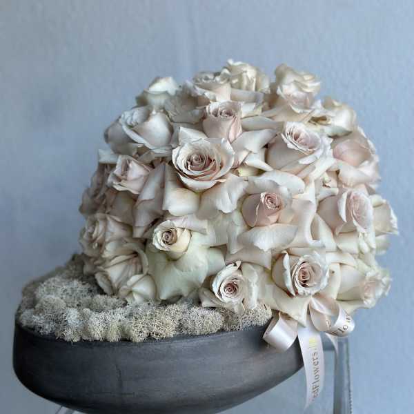 Cream rose bouquet in a black bowl with a ribbon
