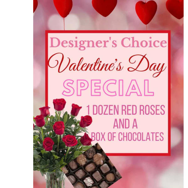 Red roses in a glass vase beside a box of chocolates and a Valentine’s Day sign.