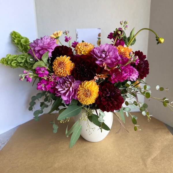 Colorful dahlia bouquet in a white vase