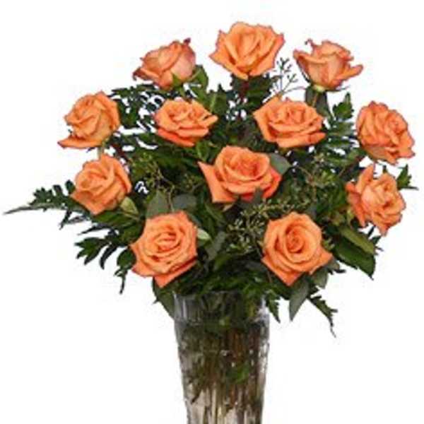 Orange roses arranged in a clear glass vase