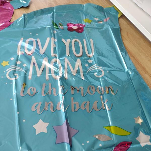 Blue foil balloon with the words "Love you Mom to the moon and back"