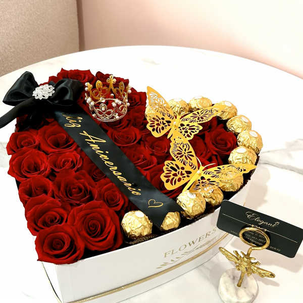 Heart-shaped box of red roses with gold-wrapped chocolates and butterfly decorations