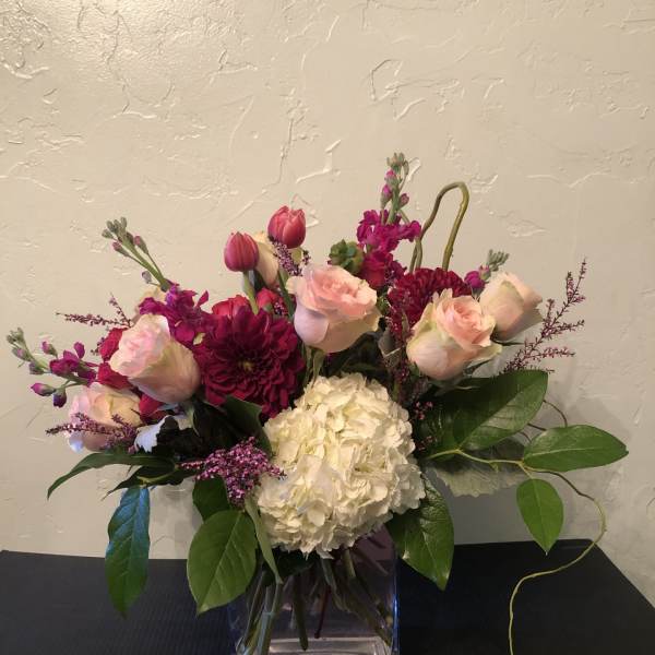 Pink roses and white hydrangea in a clear square vase