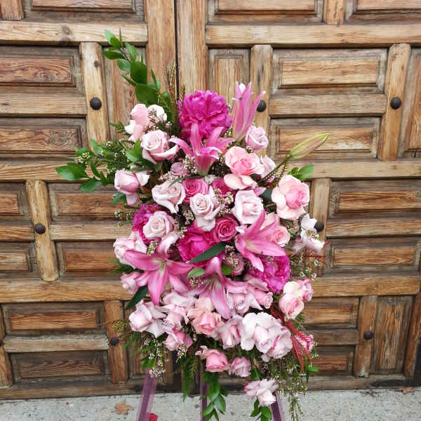 Pink and white floral standing arrangement on a purple easel