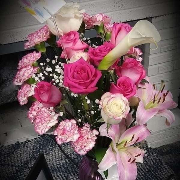 Pink and white rose bouquet with lilies and carnations in a vase