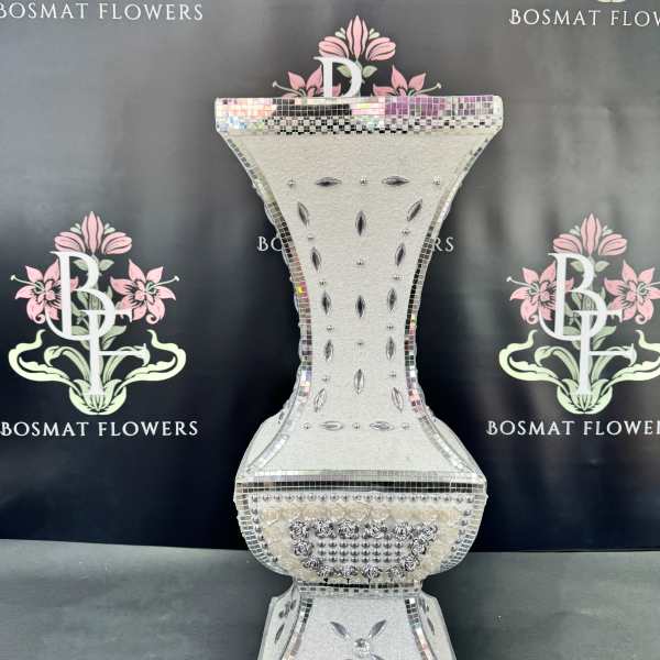 Decorative silver mosaic pedestal vase on a black backdrop