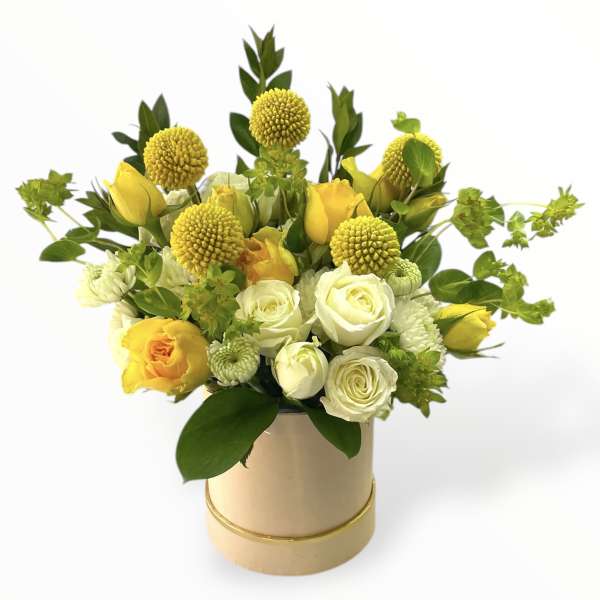 Yellow and white roses in a round beige box