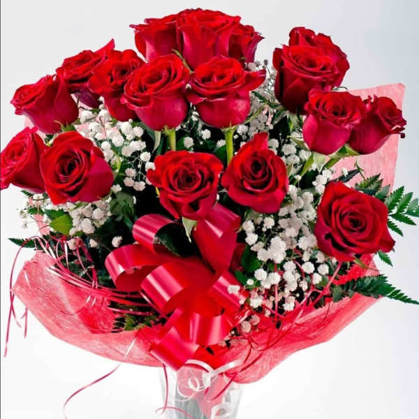 Bouquet of red roses with baby's breath in a clear glass vase