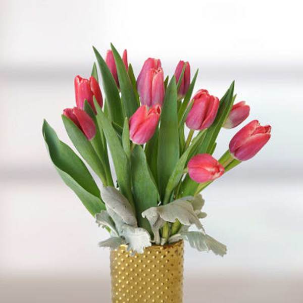 Pink tulips arranged in a gold dotted vase