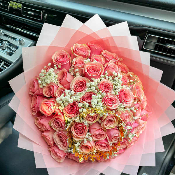 Large bouquet of pink roses wrapped in translucent pink paper