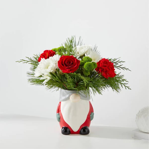 Red and white flowers arranged in a Santa-shaped vase