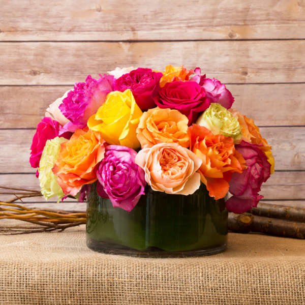 Colorful rose bouquet in a dark glass vase