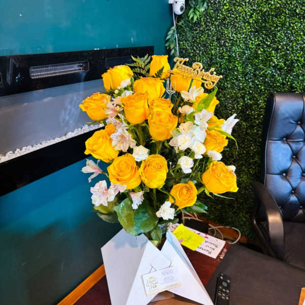 Yellow rose bouquet with white accent flowers and a birthday topper