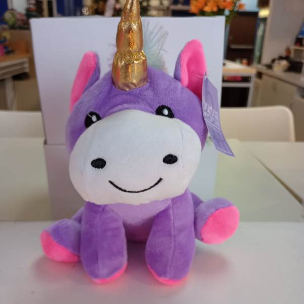Purple unicorn plush toy with a gold horn and pink accents