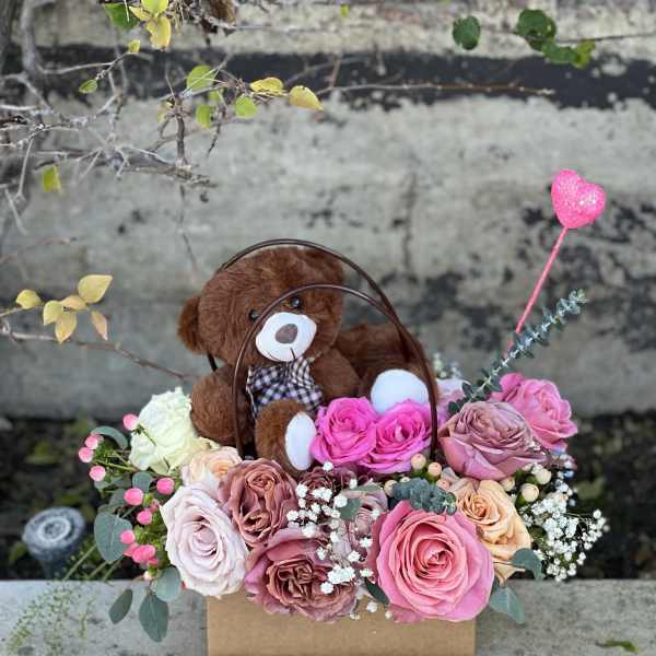 Teddy bear in a box with pink and blush roses