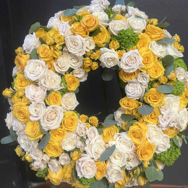 Large circular wreath of yellow and white roses with eucalyptus accents