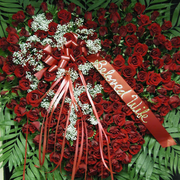 Heart-shaped red rose wreath with ribbon and white baby's breath