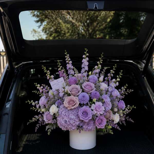 Lavender rose and hydrangea arrangement in a white vase