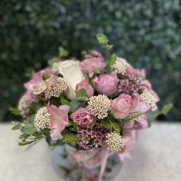 Pink and white bouquet with roses in a clear vase