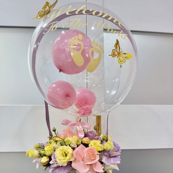 Pink balloon bouquet with flowers in a striped box