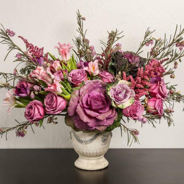 Pink and purple floral arrangement in a white vase
