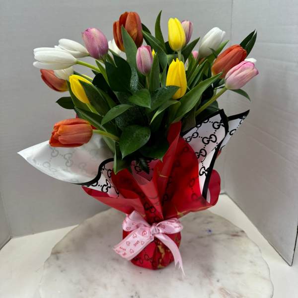 Bouquet of multicolored tulips wrapped in red and white paper