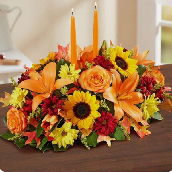 Autumn floral centerpiece with orange candles and mixed blooms