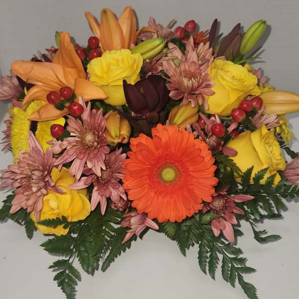 Mixed bouquet with orange lilies, yellow roses, and an orange gerbera daisy