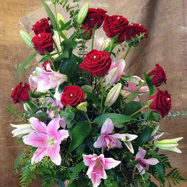 Red roses and pink lilies in a glass vase