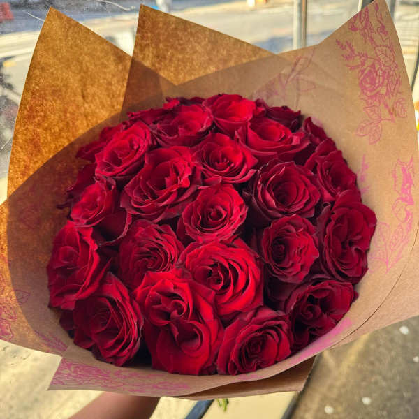 Bouquet of red roses wrapped in brown paper