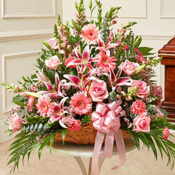 Pink mixed flower basket with roses, lilies, and a ribbon