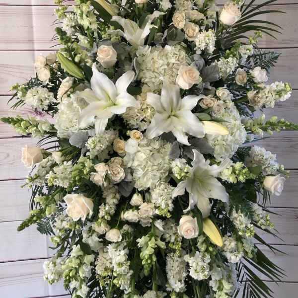 Large white funeral spray with lilies, roses, and hydrangeas