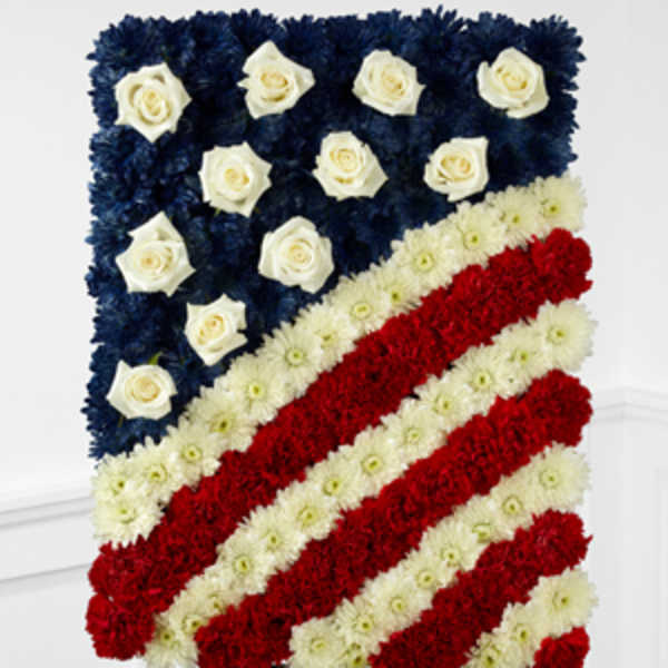 Floral arrangement shaped like the American flag with red, white, and blue flowers