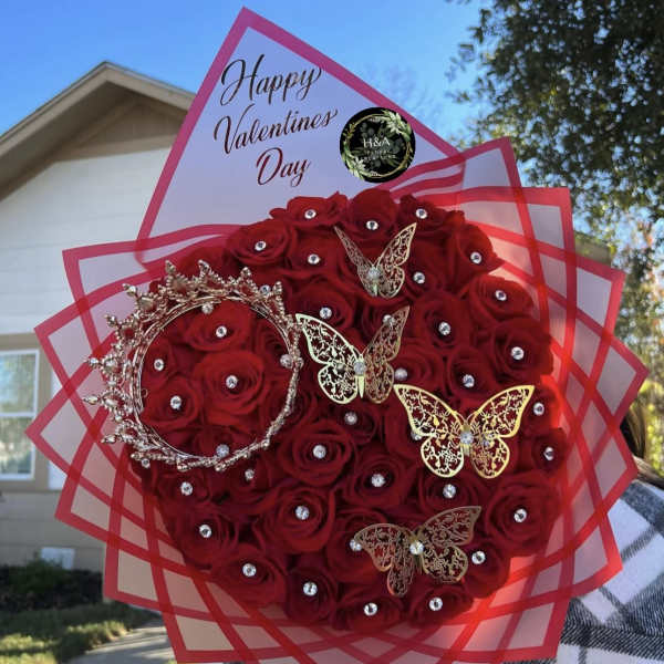 Red rose bouquet with rhinestones, butterfly picks, and a Valentine's Day topper